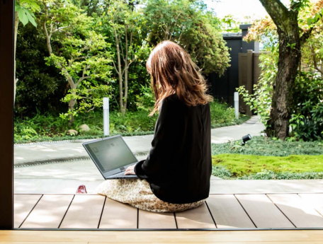 woman sitting outside while using laptop